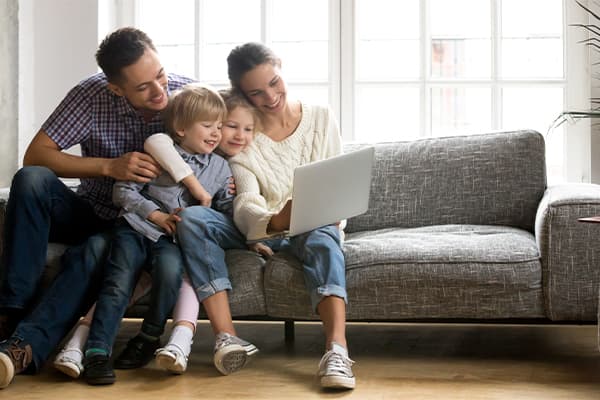 Happy-family-with-little-kids-enjoying-using-application-on-laptop-together